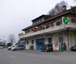 AGROLA Tankstelle in Mollis, bei Wohnhaus neben Garage. Eine Tanksäule mit Zahlterminal. Neblige Bildaufnahme.