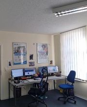 Ein Schulungsraum mit zwei Arbeitsplätzen. Jeder Arbeitsplatz hat einen Schreibtisch, zwei Monitore, eine Maus und eine Tastatur