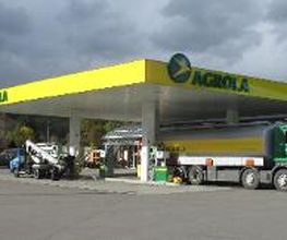 AGROLA Tankstelle in Neftenbach; überdacht mit TopShop; bei Tankstelle grosser AGROLA Lastwagen; bewölkter, grauer Himmel; grosser Vorplatz