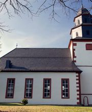 Unser Kirchenschiff wurde in der Zeit zwischen 1721 und 1724 neu erbaut. Die Pläne hierfür stammen von dem Hanauer Baumeister Johannes Daniel Stark. Unser Kirchenschiff ist eine Saalkirche mit rechteckigem Grundriss, die Flachdecke und die Empordecken sind mit Stuckringen und Ellipsen geschmückt. Über dem Triumphbogen zur Taufkapelle im Turm sehen Sie das bemalte steinerne Wappen der Patrone unserer Kirche, der Freiherren Riedesel zu Eisenbach. Im Innern des Turmes befinden sich mittelalterliche Malereien etwa aus der Zeit um 1380.