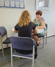 Zwei Frauen an einem Tisch im Gespräch.