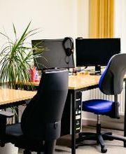 Arbeitsplätze mit PC und blauen Stühlen