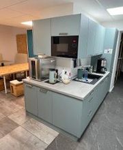 Aufenthaltsraum mit mehreren Sitzmöglichkeiten und Küchenzeile (Spüle, Mikrowelle, Wasserkocher, Kaffeemaschine)