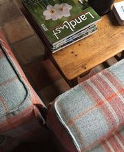 Martin Otto Thie Raumgestaltung Inh. Aline Sander e.K. Detailansicht eines Sofas mit hochwertigem karierten Wollstoff in Blau-Rot. Saubere Nähte und exakte Verarbeitung zeigen die handwerkliche Präzision in Polsterarbeiten und Stoffauswahl.