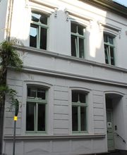 Dreistöckiges weißes Gebäude aus der Gründerzeit.