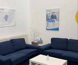 Pausenraum mit zwei Sofas und einem Beistelltisch. An der Wand ein Kalender und ein Plakat.