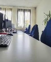 Arbeitsplatz mit Stuhle und mit Bildschirm und Tastatur