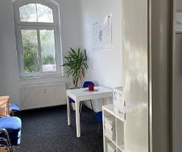Pausenraum für Teilnehmer mit einem Tisch und mehreren Stühlen
