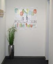 WBS - Eingangsbereich mit Pflanze und einem Plakat, auf dem "Education is the foundation of the future" steht.