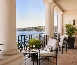 Private terrace with seating area and panoramic lake and city views from The Woodward Geneva suite.