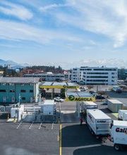 AGROLA Tankstelle mit Ansicht der Wasserstoff-Tankstelle. Links ist der Hydrospider-Container. zu sehen. Rechts eine Karawane an H2-LKW.