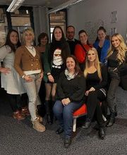 Team aus 10 freundlichen Personen in einem Schulungsraum.