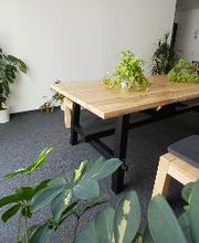 Sitzbänke mit Sitzkissen an einem Tisch mit Topfpflanzen