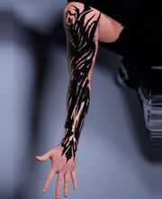 Blastover Sleeve auf dem Arm. Abstrakte schwarze Elemente wurden genutzt um die alte Tätowierung in den Hintergrund treten zu lassen.