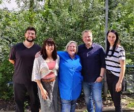 Ein Gruppenfoto vom Standortteam bestehend aus 3 Frauen und 2 Männern. Die Personen stehen draußen im Grünen.