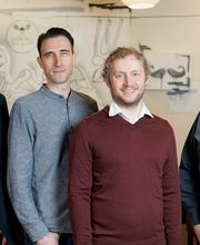 Die vier Gründer von gastronovi stehen nebeneinander und lächeln in die Kamera, vermutlich während einer Veranstaltung oder eines Treffens, das mit der Gastronomiebranche in Verbindung steht. Dieses Bild könnte eine Präsentation oder ein Firmenevent von gastronovi darstellen.