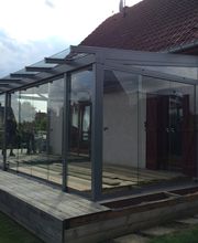 Terrassenüberdachung mit Ganzglasschiebetüren und Dachüberstand