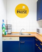 Küche mit Spülbecken und blauen Küchenschränken, Spüle, Spülmaschine und Mikrowelle.