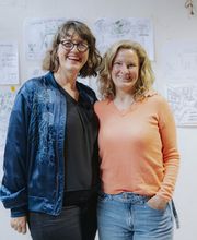 Abschlussmoment eines Workshops mit entstandenen Visualisierungen im Hintergrund bei Martina Grigoleit – Graphic Recording in Lübeck.