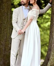 Ein verliebtes Brautpaar steht am Baum und blickt gemeinsam in die Ferne