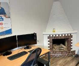 Schulungsraum im Kaminzimmer. Ein Arbeitsplatz mit einem Schreibtisch, zwei Monitoren, Tastatur und Maus