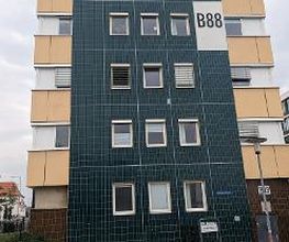 Außenansicht vom Gebäude der Einrichtung. Blaue Kacheln und orangene Fassade.