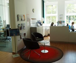 Empfangs- und Beratungsbereich mit Theke und Sitzmöglichkeiten.