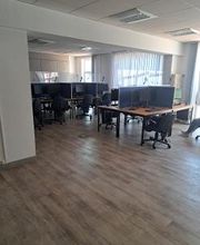 Raum mit mehreren Arbeitsplätzen mit jeweils 2 Bildschirmen, einem Bürostuhl, Tastatur und Maus. 