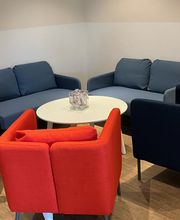 Aufenthaltsraum mit 2 gemütlichen blauen Sofas sowie einem roten Sessel.