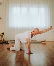 Achtsame Yogapraxis im Vierfüßlerstand mit Armöffnung in einem ruhigen, klaren Studio. Die Haltung unterstützt Mobilität, Stabilität und bewusste Bewegung.
