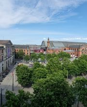 Blick aus dem Fenster auf das Bahnhofsgelände mit einem schönen, großen Gebäude.