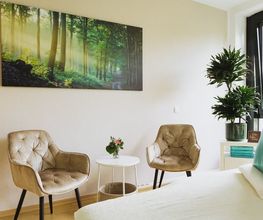 Heller Behandlungsraum von Physiotherapie Birkhoff mit Therapieliege, Sitzbereich und ruhigem Waldmotiv. Das Bild vermittelt eine angenehme Atmosphäre für individuelle Physiotherapie Magdeburg, Schmerztherapie Magdeburg und ganzheitliche Behandlung.
