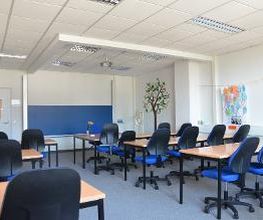 Klassenraum der WBS SCHULEN Chemnitz mit Tischen und Stühlen.