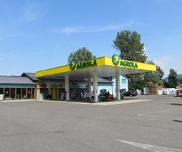 AGROLA Tankstelle in Alle mit TopShop; station-service AGROLA à Alle avec un TopShop; grosser Platz im Vordergrund; maison à gauche c'est un LANDI
