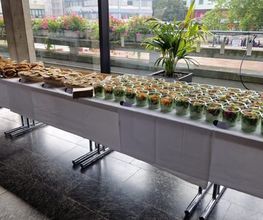dean&david Catering | Pforzheim - Langes Catering Buffet mit Wraps, Sandwiches und vielen Bowls im Glas vor großer Fensterfront für Empfang, Tagung oder Business Lunch.