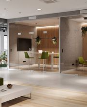 Ein stilvoll gestaltetes Büro mit modernen Loungemöbeln und innovativen Meetingräumen. Die Kombination aus natürlichen Materialien, Glaswänden und ergonomischen Sitzmöbeln schafft eine produktive und zugleich entspannte Arbeitsatmosphäre.