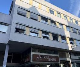 Frontansicht auf Bürogebäude, im unteren Eingangsbereich Logo und Eingangsbereich eines Fahrradladens.