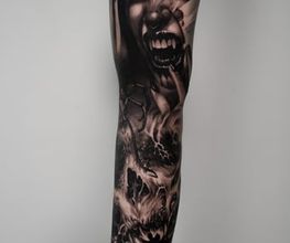 fullsleeve auf dem Arm, Black und Gray Horror Tattoo. Das Gesicht einer Vampirfrau ist das Hauptmotiv.