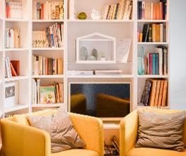 Eine Sitzecke mit Sesseln und dahinter einem Bücherregal.