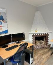 Schulungsraum im Kaminzimmer. Ein Arbeitsplatz mit einem Schreibtisch, zwei Monitoren, Tastatur und Maus