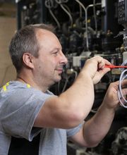 Unser Servicetechniker für Antriebstechnik, bei der Arbeit an einem Danfoss Frequenzumrichter.