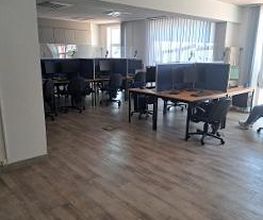 Raum mit mehreren Arbeitsplätzen mit jeweils 2 Bildschirmen, einem Bürostuhl, Tastatur und Maus.