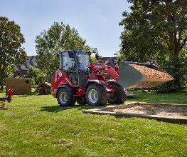 Weidemann Hoftrac 1390e mit Kabine und Leichtgutschaufel im Einsatz auf einem Spielplatz