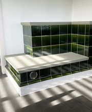 Wärme trifft Gemütlichkeit Ein Kachelofen mit integrierter Sitzbank ist mehr als nur ein Heizsystem – er ist ein Ort zum Verweilen.