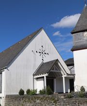 Nachdem die alte Kapelle in Hof am 11.09.1819 wegen Baufälligkeit abgerissen wurde und die Glocken lange Zeit an einem starken Baum aufgehängt waren, wurde 1830 zunächst ein Glockenturm gebaut, um die Glocken zu schützen.
Im Jahr 1958 wurde dann das Kirchenschiff angebaut und am ersten Advent 1959, genau 140 Jahre nach dem Abbruch der alten Kapelle, eingeweiht. Sehenswert ist der großzügige Kirchenraum mit seinen bunten Glasfenstern.