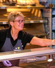 BÄCKEREI
Bei uns können Sie sich von der Bäckerei im Vorkassenbereich verwöhnen lassen. Der herrliche Duft von Broten, Baguettes, Semmeln und Brezen wird Ihnen sicher schon beim Betreten unseres Marktes in die Nase steigen. Wer es lieber süß mag, kommt hier selbstverständlich auch auf seine Kosten. Für Schleckermäulchen gibt es Quarktaschen, Apfeldreiecke, Johannestaler, Donuts und viele weitere Köstlichkeiten.
