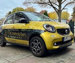 Gebrandetes Firmenfahrzeug von ROC Immobilien, Immobilienmakler in Berlin. Sichtbar sind Logo, Kontaktdaten sowie die Leistungen Beratung, Bewertung, Verwaltung und Vermittlung von Immobilien.