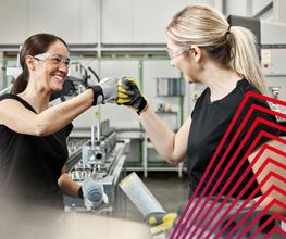 Zwei actuell Personal Mitarbeiterinnen arbeiten motiviert und teamorientiert in einer modernen Produktionshalle.