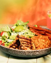 CARIBBEAN GRILLED CHICKEN , Saftige Hähnchenkeule mit Piri-Piri-Marinade, dazu spicy Reis-Quinoa-Mix, knusprige Süßkartoffel-Pommes und knackiger Salat.