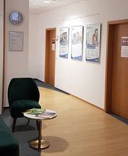 Empfang Schulungsgebäude mit Sesseln und kleinen Tischen.